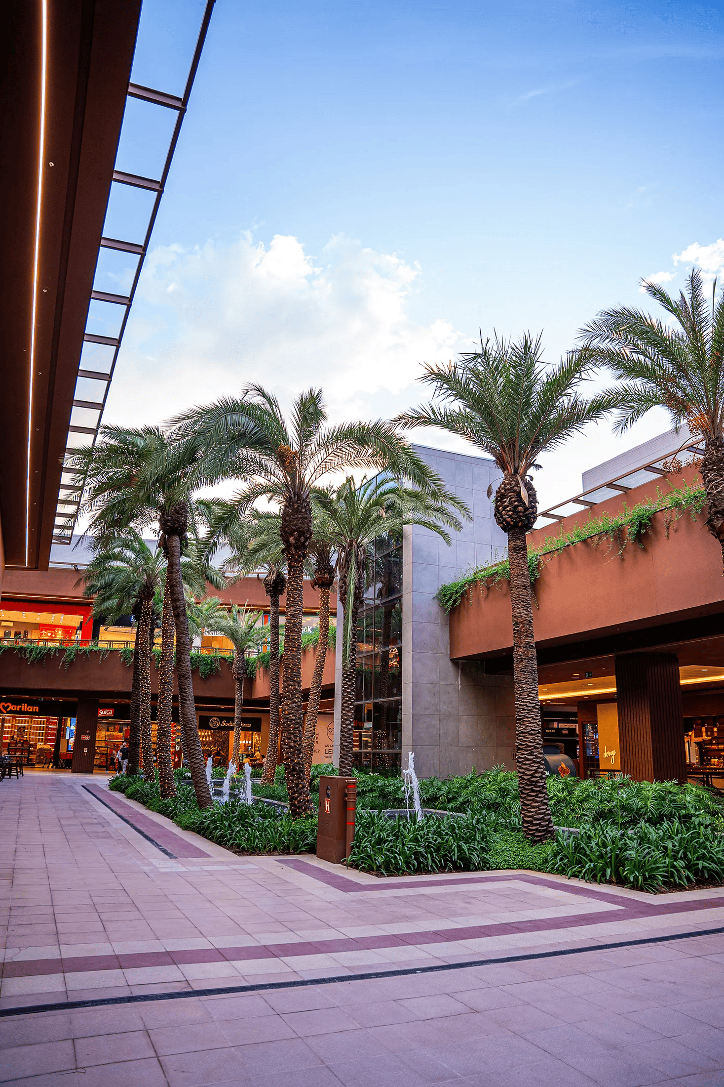 Entrada do Catarina Fashion Outlet com palmeiras e jardim